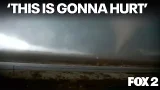 Storm chasers avoid tornado blowing debris in wild video